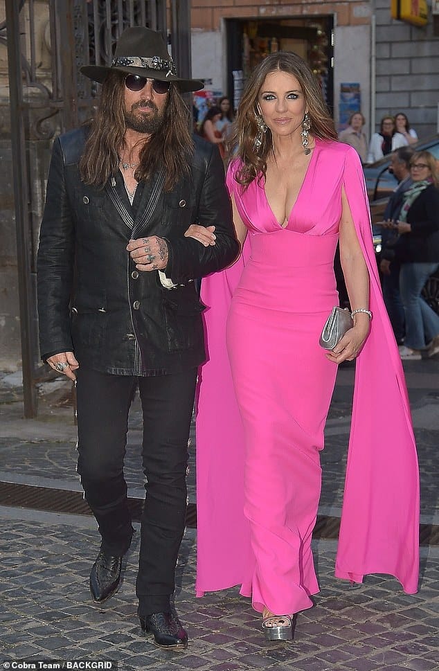 Elizabeth Hurley, 59, and Billy Ray Cyrus, 63, put on a loved up display as they make FIRST outing as a couple at swanky bash in Rome – after shocking the world with their unlikely romance