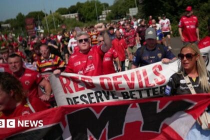 Salford Red Devils fans march in protest after game cancelled